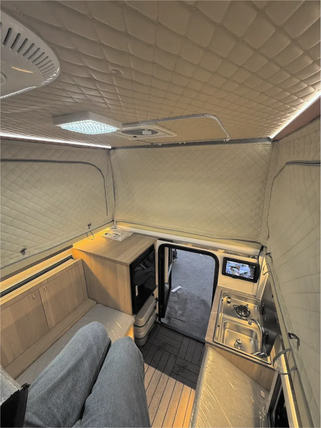 Camper interior with the kitchen unit and bed platform