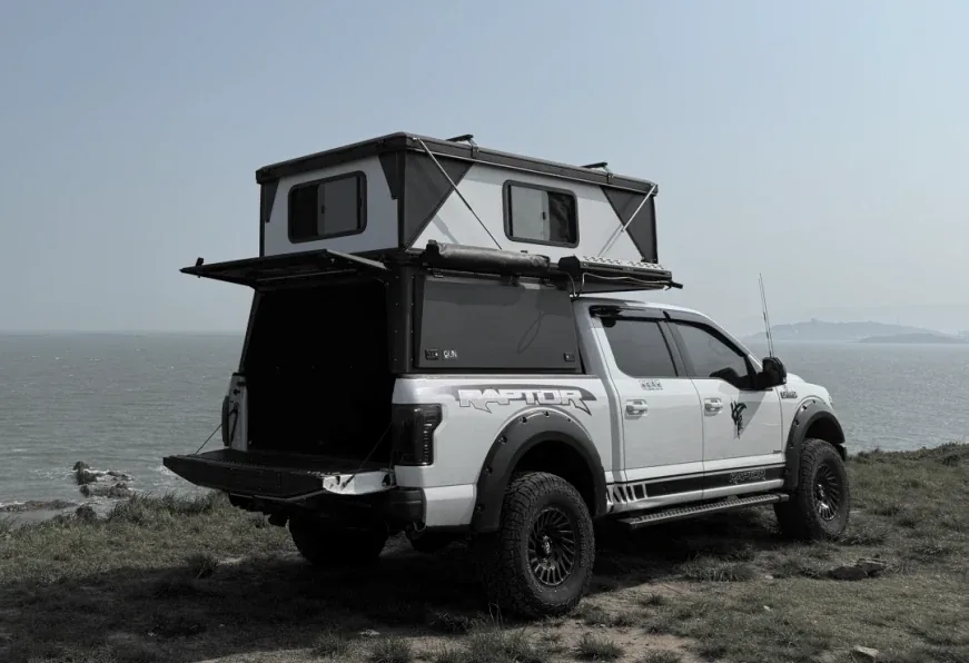 Pickup fitted with a TUYU high-cover canopy camper with the roof tent raised
