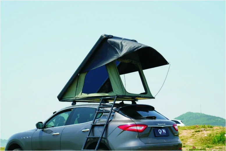 Car with the TUYU R2 hard-shell roof-top tent opened on a hillside